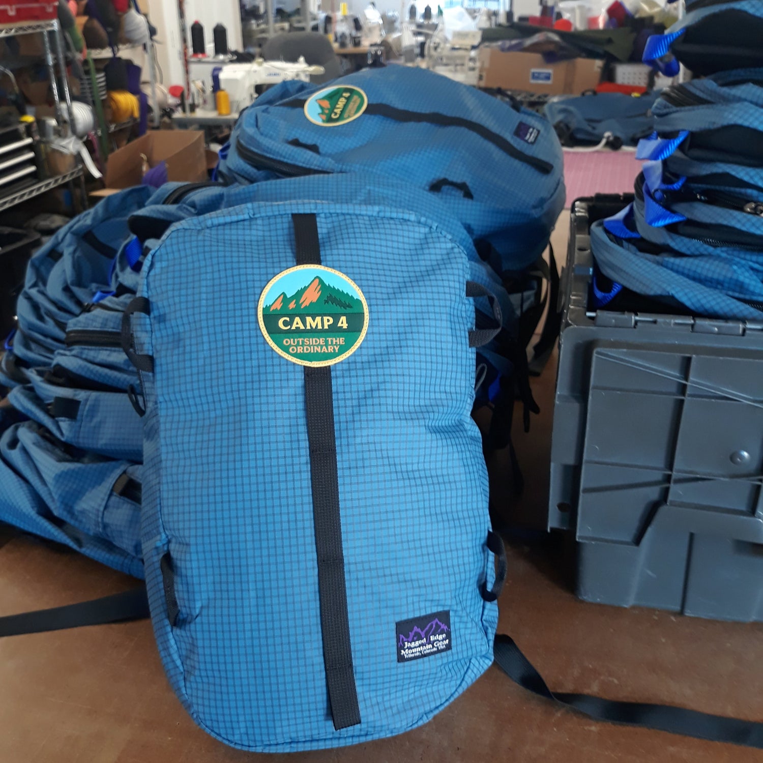 Blue backpack with a Camp 4 logo in addition to the Jagged Edge logo