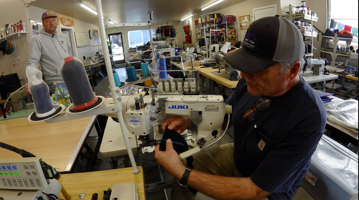 Load video: Two men walking around a warehouse with sewing equipment describing how they make bags and packs.