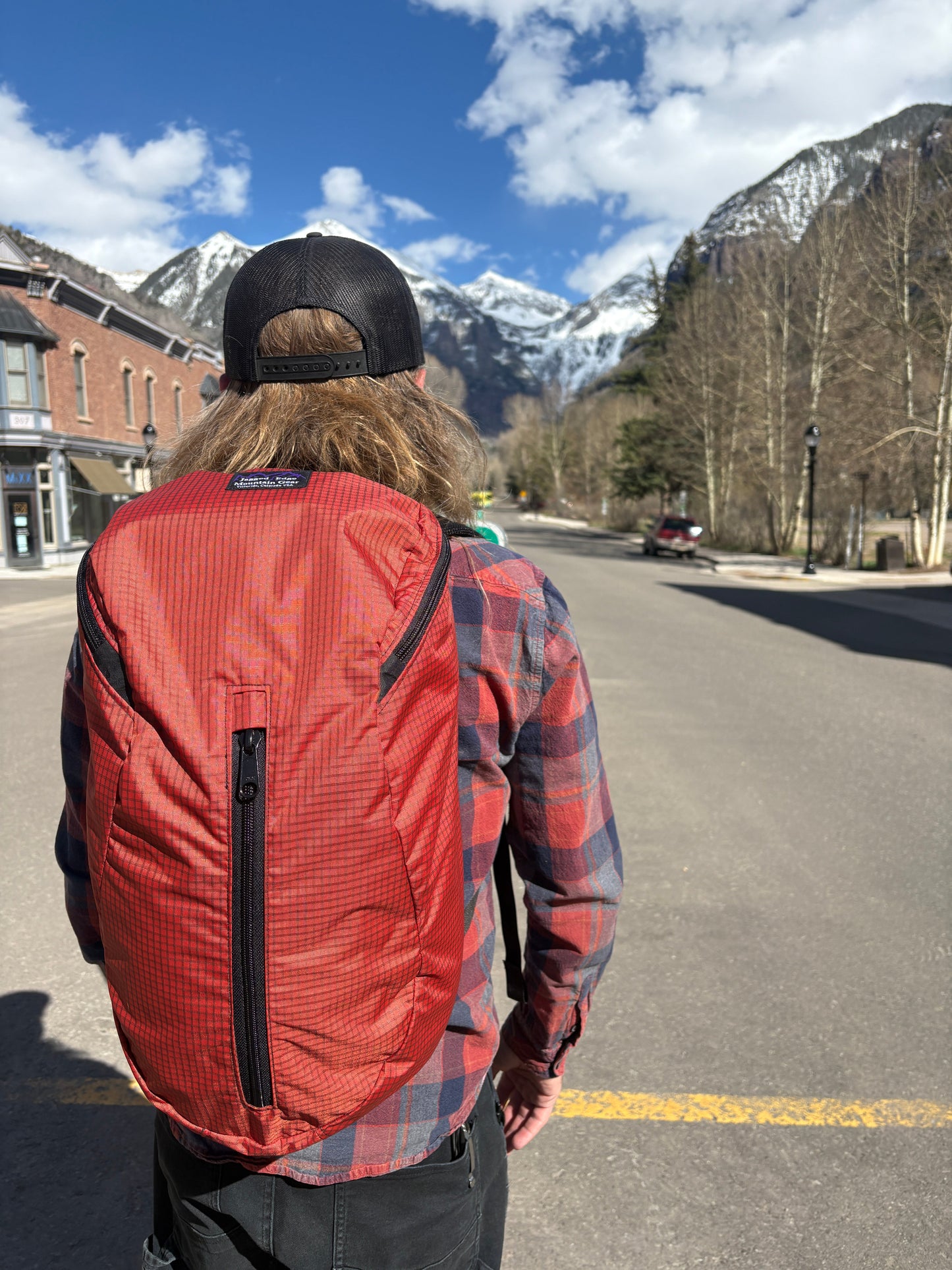 Person wearing a red Jagged Edge Ajax Pack with a scenic mountain background