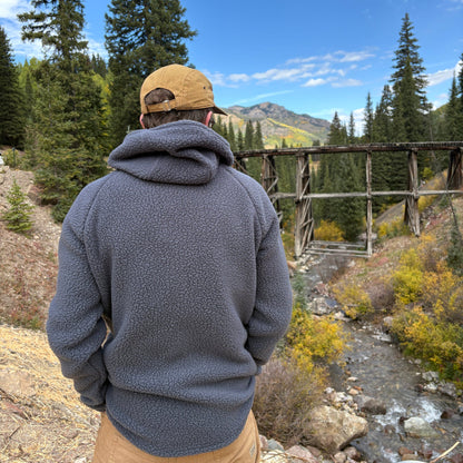 A person standing in front of the Telluride Trestle wearing the Jagged Edge High Pile Fleece Hoodie